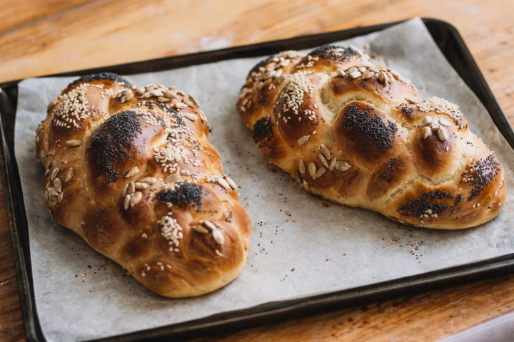 Two freshly baked challah loaves on a baking tray for Shabbat